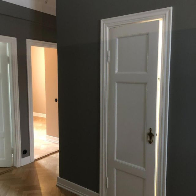 Harmaa seinä ja valkoinen ovi